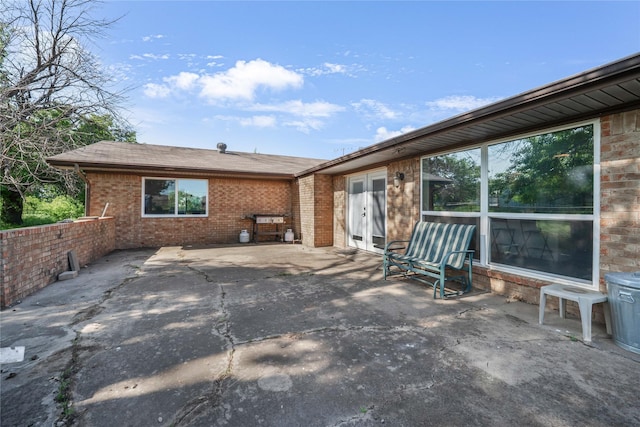 back of property with brick siding, a patio, and french doors