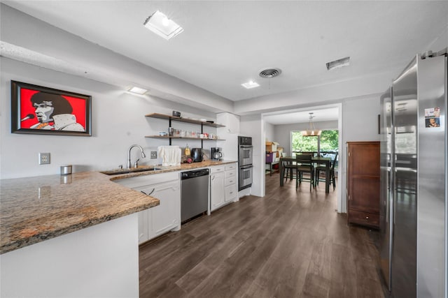 kitchen featuring a sink, appliances with stainless steel finishes, visible vents, white cabinetry, and dark wood-style floors