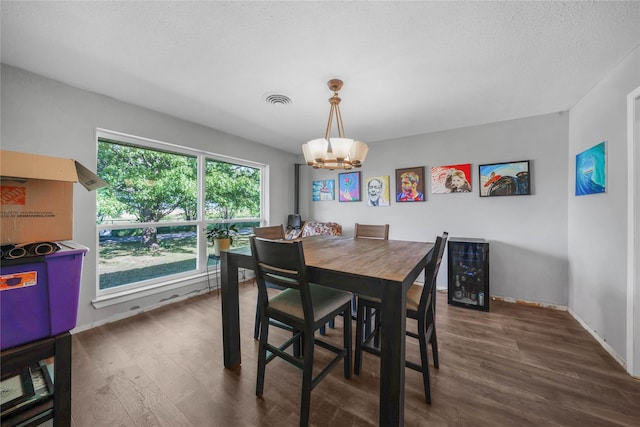 dining room with wood finished floors, visible vents, baseboards, and a notable chandelier