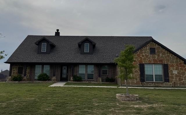view of front of property with stone siding, a chimney, and a front lawn