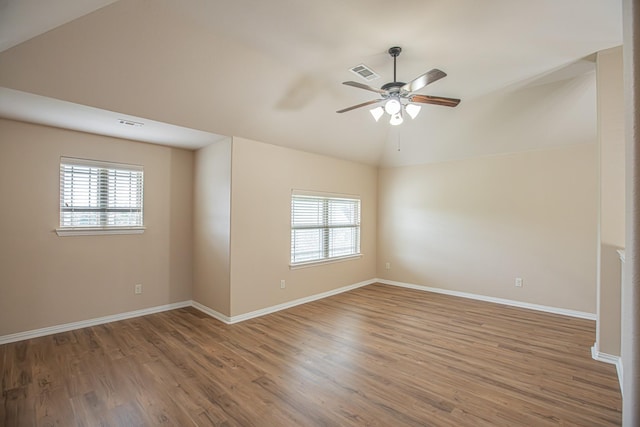spare room featuring visible vents, a ceiling fan, plenty of natural light, and wood finished floors