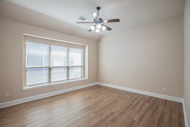 spare room featuring visible vents, a ceiling fan, baseboards, and wood finished floors