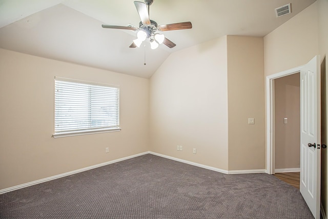 empty room with a ceiling fan, visible vents, baseboards, dark colored carpet, and lofted ceiling