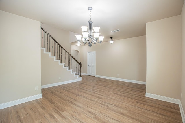 interior space with visible vents, a notable chandelier, stairway, and light wood-type flooring