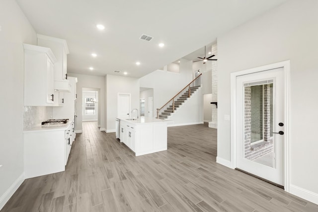 2708 Creekhollow Ct, Denton, TX 76226 - kitchen with white cabinets, white gas stovetop, light countertops, light wood-type flooring, and recessed lighting