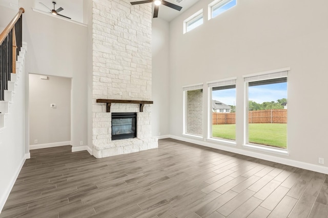 2708 Creekhollow Ct, Denton, TX 76226 - unfurnished living room with ceiling fan, a high ceiling, wood finished floors, a fireplace, and stairway