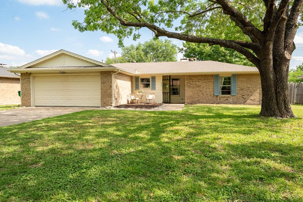 206 Myrtle Ave, Waxahachie, TX 75165 - ranch-style house with driveway, brick siding, a front yard, and a garage