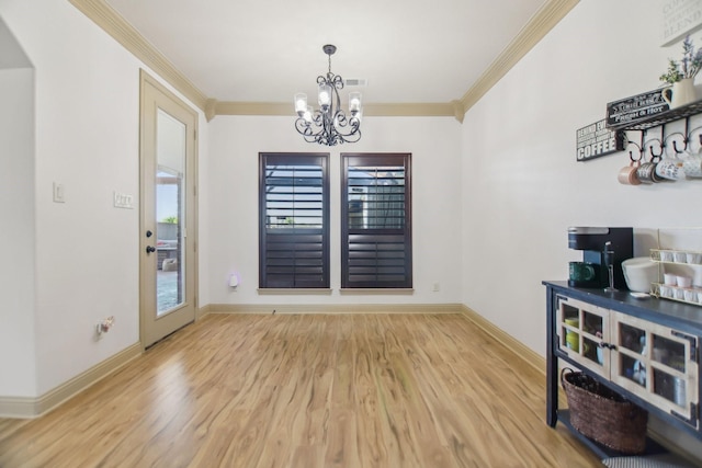 dining room featuring a chandelier, baseboards, ornamental molding, and wood finished floors