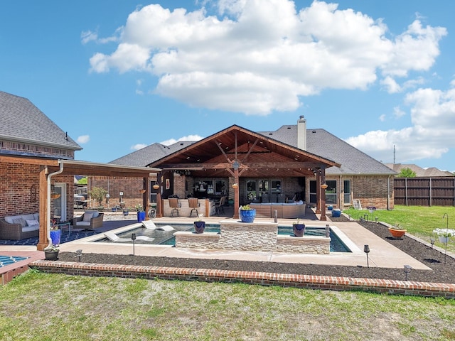 back of house with a jacuzzi, an outdoor hangout area, brick siding, and outdoor dry bar