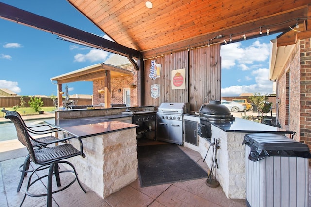view of patio / terrace featuring a grill, an outdoor kitchen, and outdoor wet bar
