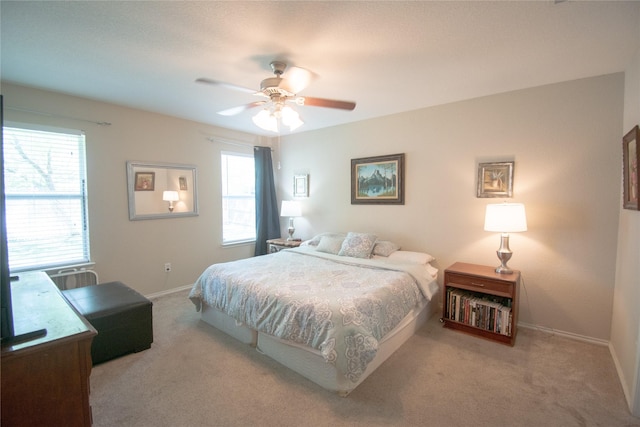 carpeted bedroom with a ceiling fan and baseboards