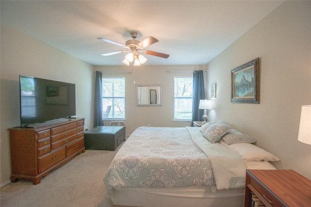 bedroom with light colored carpet and a ceiling fan