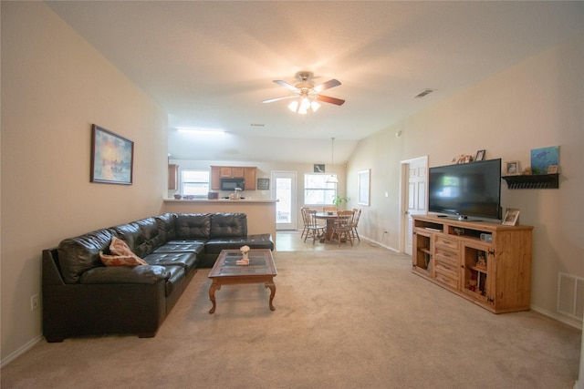 living room featuring vaulted ceiling, visible vents, a ceiling fan, light carpet, and baseboards