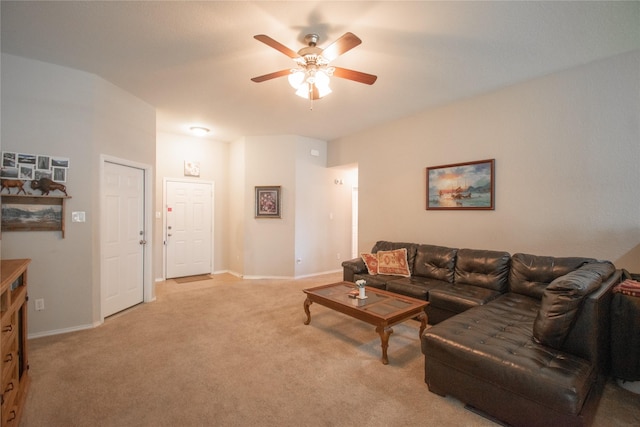 living area featuring light colored carpet, ceiling fan, and baseboards