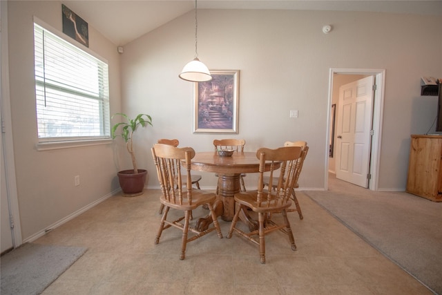 dining room featuring lofted ceiling, baseboards, and light floors