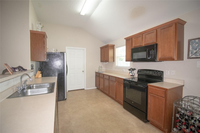 kitchen with a sink, vaulted ceiling, light floors, light countertops, and black appliances