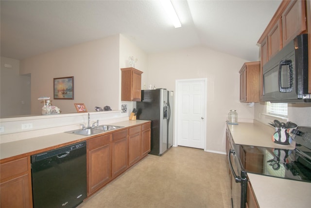 kitchen featuring brown cabinets, light countertops, vaulted ceiling, a sink, and black appliances