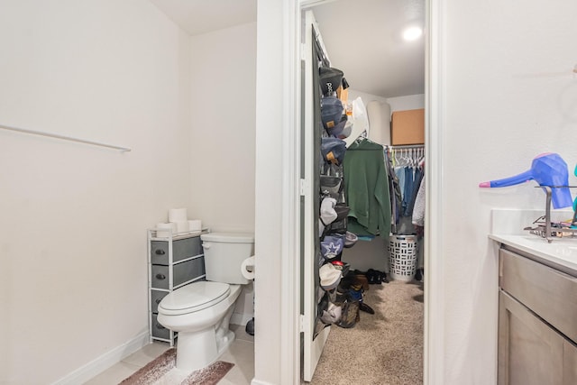 1607 Grand Villa St, Princeton, TX 75407 - bathroom with a spacious closet, toilet, vanity, and baseboards