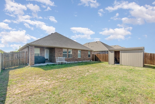 1607 Grand Villa St, Princeton, TX 75407 - rear view of property featuring a fenced backyard, a shed, an outbuilding, a lawn, and brick siding