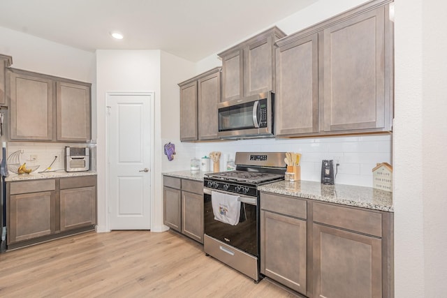 1607 Grand Villa St, Princeton, TX 75407 - kitchen with recessed lighting, light wood-style floors, decorative backsplash, light stone counters, and appliances with stainless steel finishes