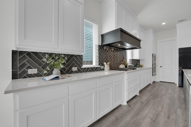 4330 Silver Spur Dr, Prosper, TX 75078 - kitchen with stainless steel gas cooktop, white cabinets, decorative backsplash, light countertops, and light wood finished floors