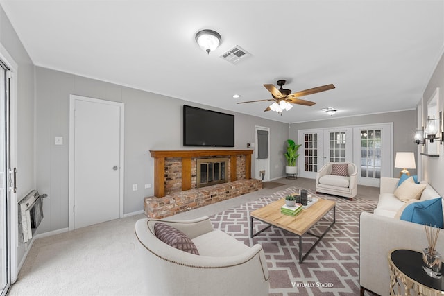 living room with visible vents, carpet, heating unit, ceiling fan, and a fireplace