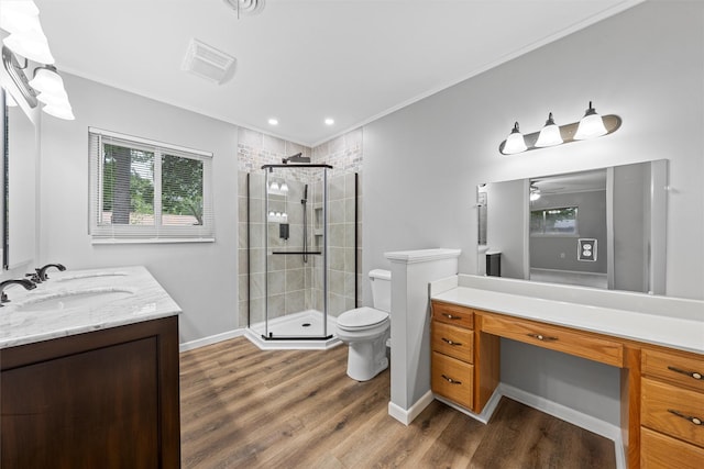 bathroom featuring wood finished floors, vanity, toilet, and a stall shower