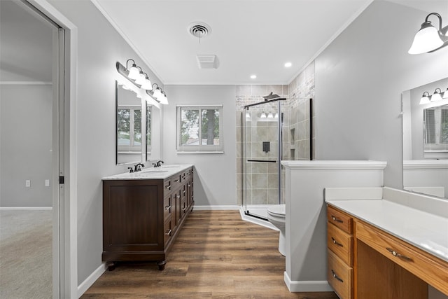 bathroom featuring a shower stall, crown molding, wood finished floors, vanity, and visible vents