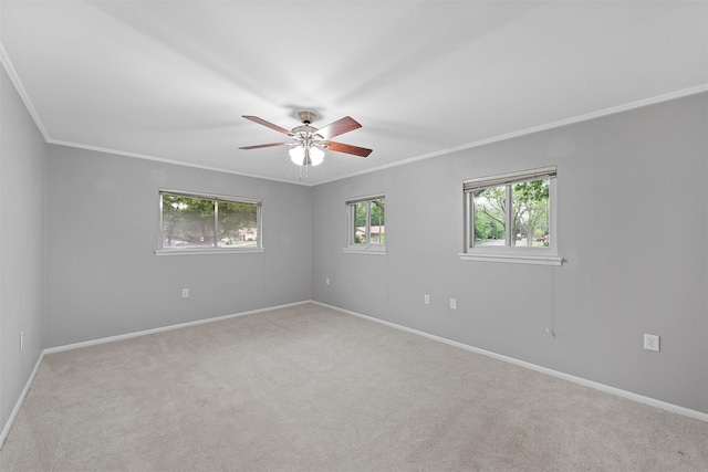 carpeted empty room featuring a ceiling fan, baseboards, and ornamental molding