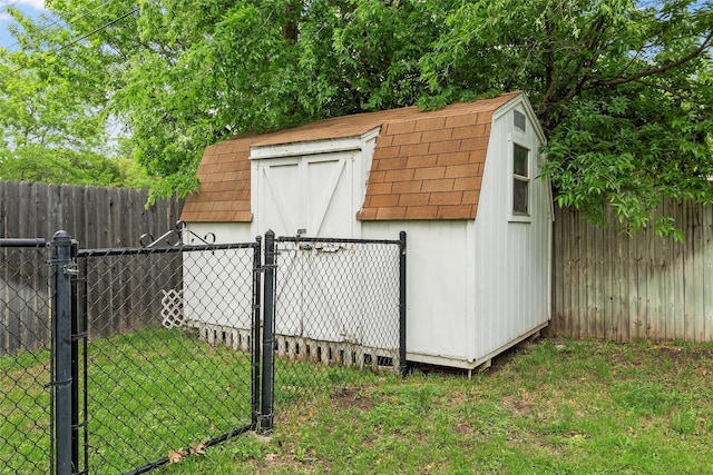 view of shed featuring a fenced backyard and a gate