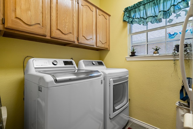 laundry room featuring washing machine and clothes dryer and cabinet space