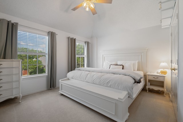 bedroom with baseboards, lofted ceiling, a ceiling fan, and light colored carpet