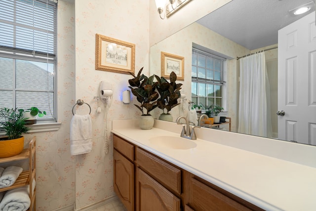 full bath featuring wallpapered walls and vanity