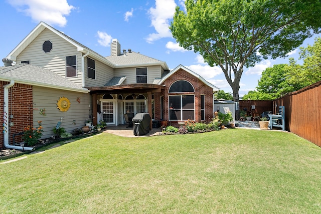 back of property with a fenced backyard, a chimney, a shingled roof, a shed, and a patio
