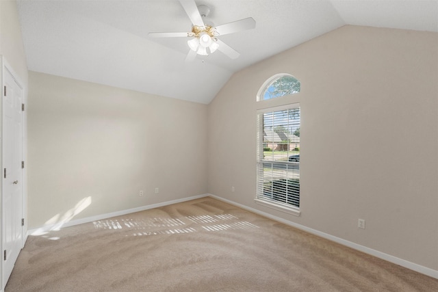 spare room with lofted ceiling, baseboards, carpet flooring, and ceiling fan