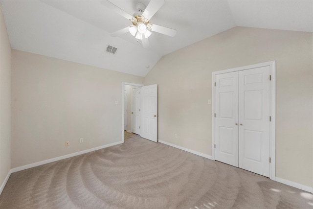 unfurnished bedroom featuring lofted ceiling, visible vents, baseboards, and carpet