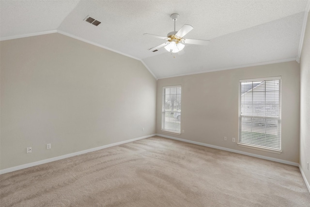empty room with lofted ceiling, visible vents, and light carpet