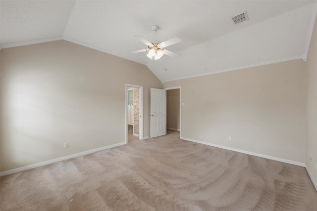 empty room with vaulted ceiling, baseboards, visible vents, light colored carpet, and ceiling fan