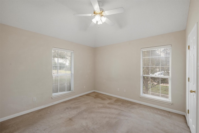 spare room with baseboards, lofted ceiling, light colored carpet, and ceiling fan