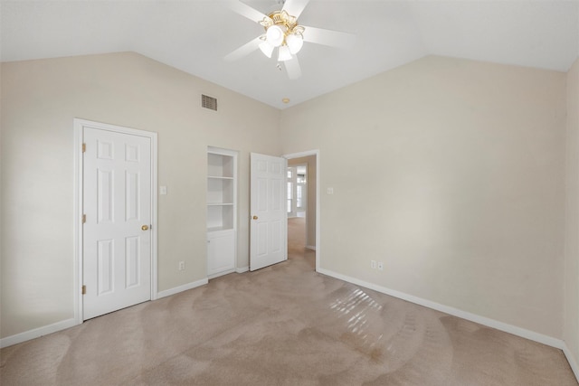 unfurnished bedroom featuring lofted ceiling, visible vents, carpet flooring, and baseboards