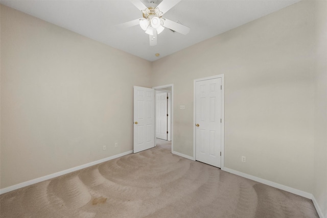 unfurnished bedroom featuring baseboards, a ceiling fan, and light colored carpet