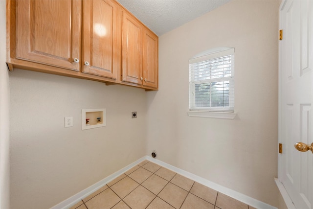 laundry room with electric dryer hookup, light tile patterned floors, cabinet space, baseboards, and washer hookup