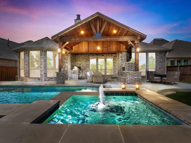 view of swimming pool featuring a fireplace, fence, and a patio area