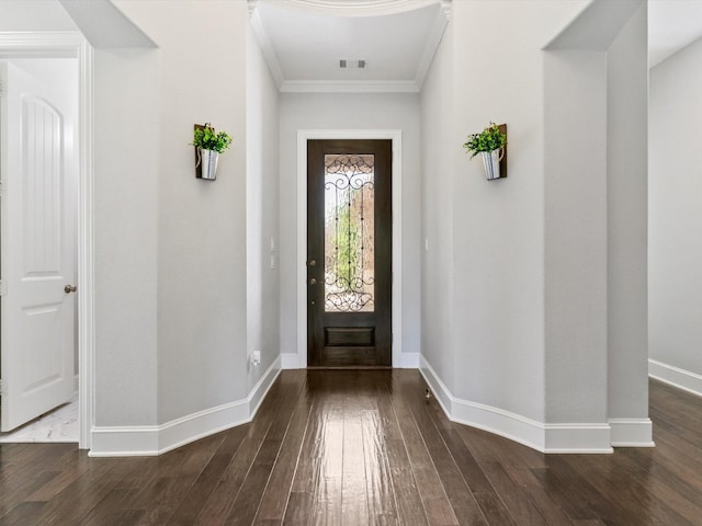 entryway featuring baseboards, ornamental molding, hardwood / wood-style flooring, and visible vents