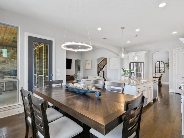2908 Ballater Ct, The Colony, TX 75056 - dining space featuring arched walkways, stairway, dark wood-style flooring, recessed lighting, and baseboards