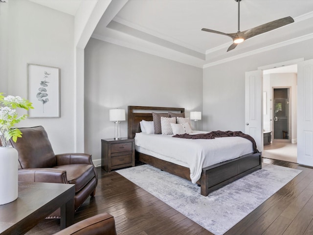 bedroom featuring crown molding, baseboards, dark wood-style floors, and a raised ceiling