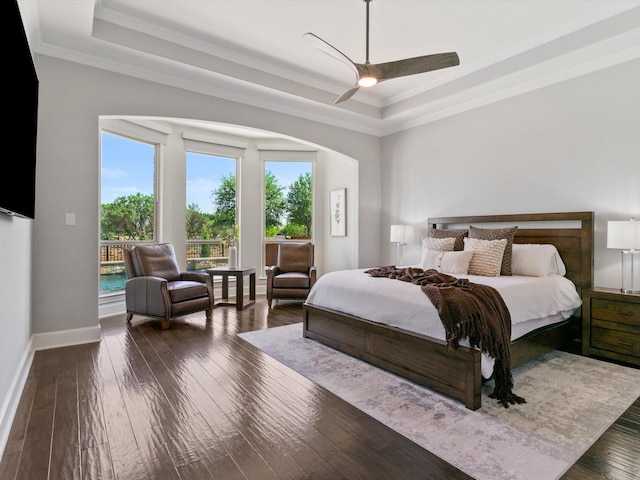 bedroom featuring crown molding, a tray ceiling, access to exterior, and wood-type flooring