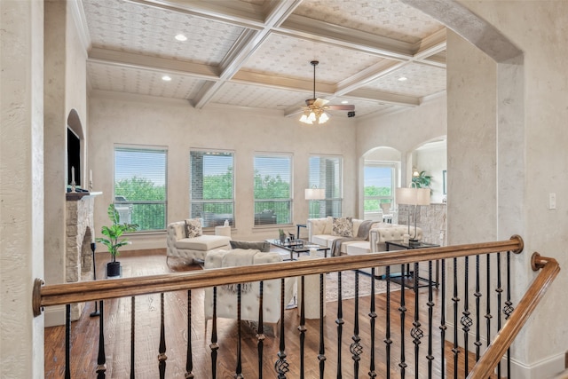 living room with plenty of natural light, beam ceiling, coffered ceiling, and wood finished floors