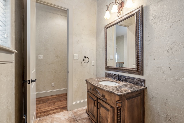 bathroom featuring vanity, baseboards, and wood finished floors