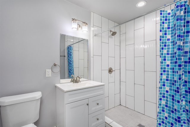 bathroom featuring recessed lighting, toilet, vanity, and tiled shower